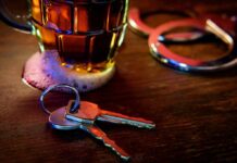 House keys on bar beside beer mug and handcuffs