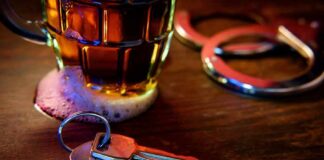 House keys on bar beside beer mug and handcuffs