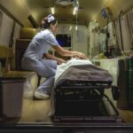 Nurse attending patient on stretcher inside ambulance