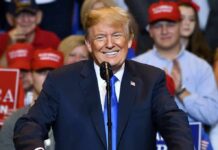 Bald Spot Banter Ignites Texas Crowd smiling man in suit at a microphone