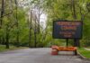 Governor Issues Urgent Evacuations Portable electronic road sign on a quiet tree-lined street
