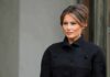 Melania Trump in a black coat looking to the side