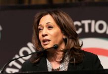 Husband Pushback Rattles Harris 2028 Kamala Harris speaking at a podium with a microphone