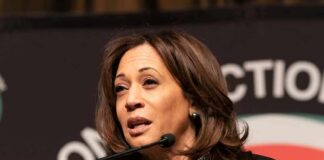Kamala Harris speaking at a podium with a microphone