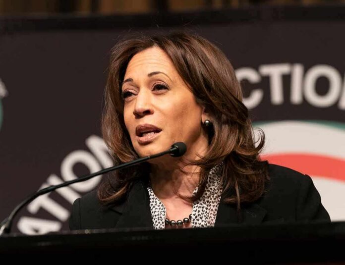 shutterstock_1360758878 Kamala Harris speaking at a podium with a microphone