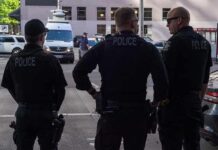 Police officers stand on a city street