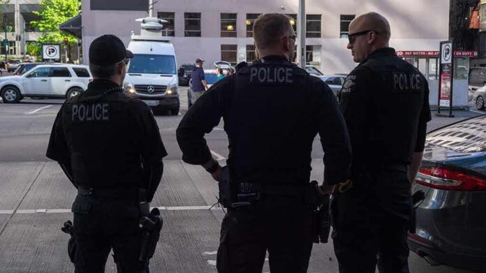 Police officers stand on a city street
