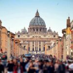 Vatican Confirms Alarming Papal Diagnosis St. Peter's Basilica viewed from a busy street with crowds