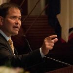 Marco Rubio speaking at a podium and gesturing with his hand