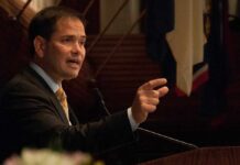 Awkward Athens Standoff – Rubio Won’t Bite Marco Rubio speaking at a podium and gesturing with his hand
