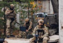 American Tech Powers Russia’s New Jet-Drone Quadcopter drone flying near camouflaged soldiers outdoors