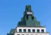 abc logo atop green-stepped building against clear blue sky