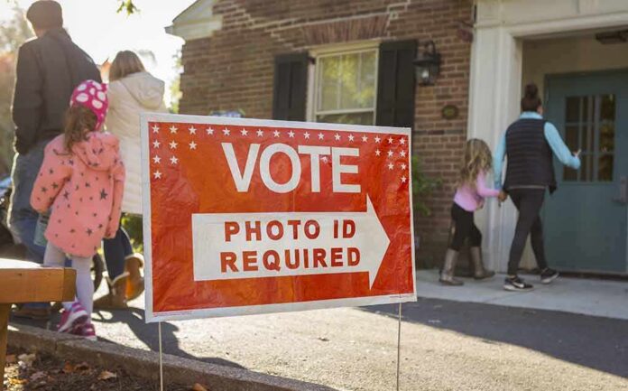 shutterstock_512254585-2 Red voting sign with arrow near people entering a polling place