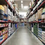 Warehouse aisle with tall shelves stacked with boxes and bulk goods