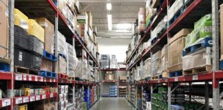 Warehouse aisle with tall shelves stacked with boxes and bulk goods