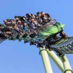 Fatal Drop Sparks Six Flags Fury roller coaster train with riders on a curved track