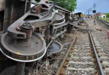 Red Signal, Green Light – Hundreds Pay Overturned train cars beside railway tracks
