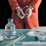 Tennessee Tried Twice. She Was Still Alive Handcuffed person in orange jumpsuit behind medical vials and IV equipment
