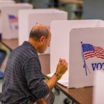 Person voting in a polling booth.