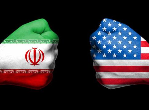 Two fists painted with Iran and USA flags.