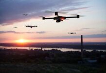 Drones flying at sunset over a landscape.