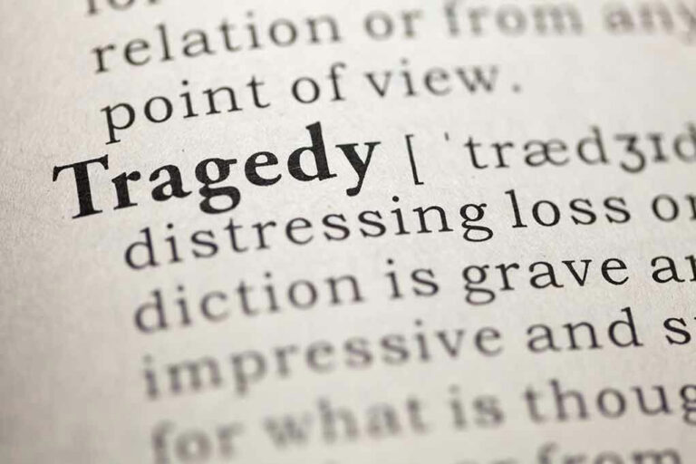 Close-up of the word Tragedy in a dictionary