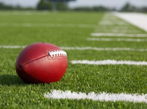 Football resting on a grassy field.