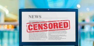 Laptop screen displaying censored news article.
