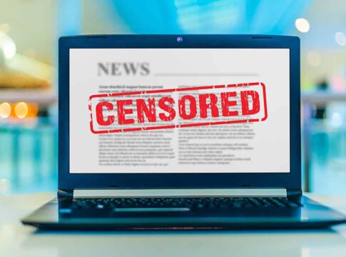 Laptop screen displaying censored news article.