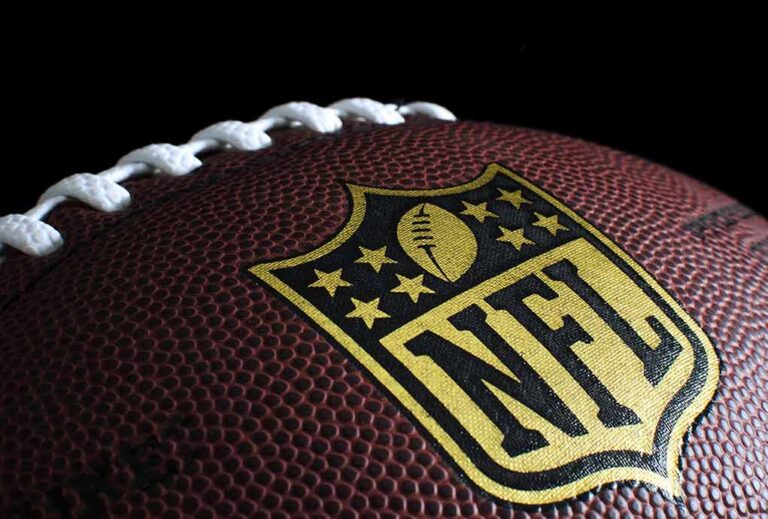 Close-up of NFL logo on brown football.