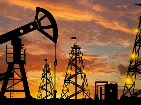 Oil rigs silhouetted against a sunset sky.