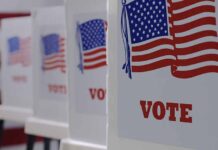 Voting booths with American flags and VOTE signs