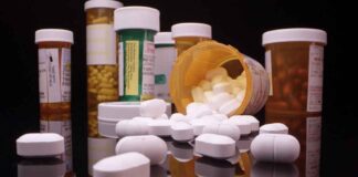 Assorted prescription pill bottles and tablets scattered.