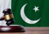 Gavel with Pakistan flag in the background.