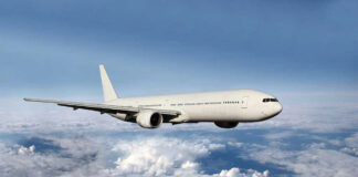 Airplane flying above the clouds, blue sky background.