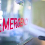 Red EMERGENCY sign on glass door.