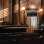 Empty courtroom with sunlight streaming through windows.