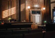 Empty courtroom with sunlight streaming through windows.