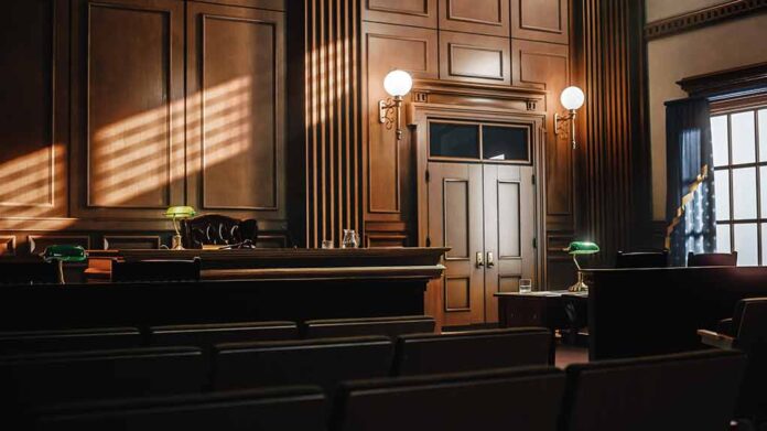 Empty courtroom with sunlight streaming through windows.