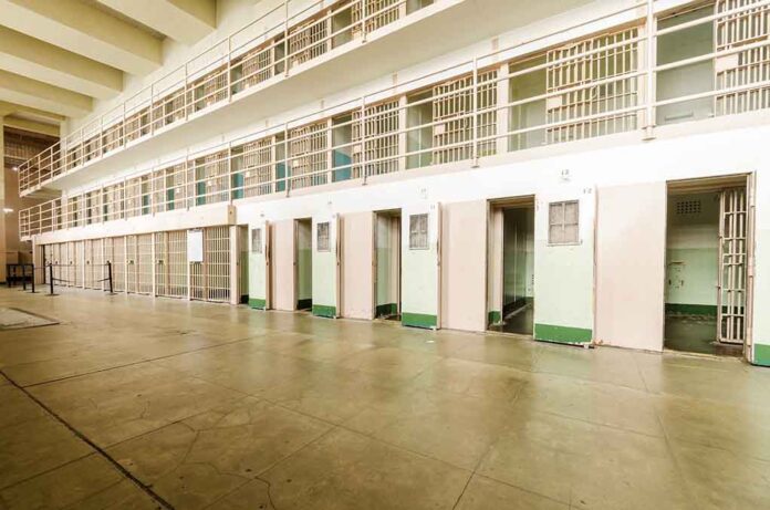 Empty prison cells in a hallway.