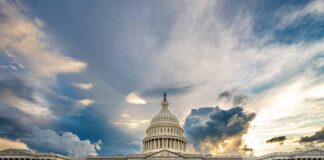 U.S. Capitol building under a dramatic sky at sunset.