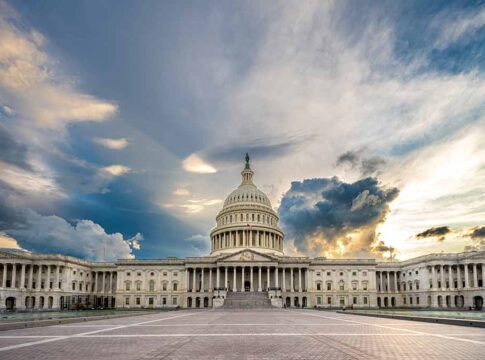 U.S. Capitol building under a dramatic sky at sunset.