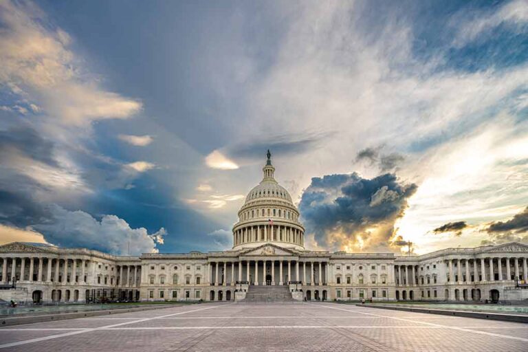 U.S. Capitol building under a dramatic sky at sunset.