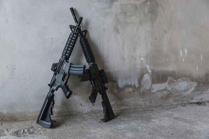 Two rifles leaning against a concrete wall.