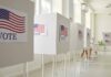 Voting booths with American flag signs.