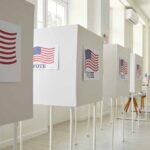 Voting booths with American flag signs.