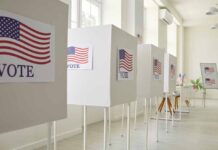 Voting booths with American flag signs.