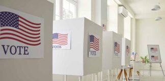 Voting booths with American flag signs.