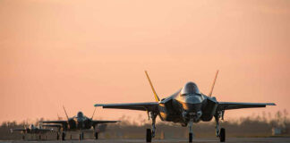 Jets on runway at sunset.