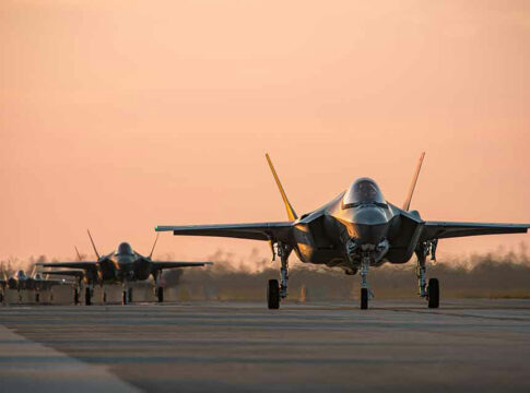 Jets on runway at sunset.